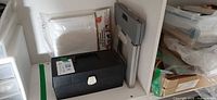 Shelf with closed tackle box, folded stool, packaged drop cloth visible