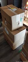 stack of three closed cardboard boxes containing the clothing
