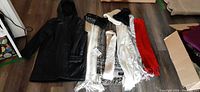 Overall lot with coat, scarves, hats arranged on floor