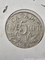 Reverse of 1934 Canada 5-cent coin showing denomination and maple leaves