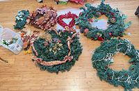 Group shot of all wreaths and bin of picks on floor