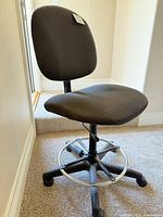 Overall view of black adjustable rolling chair with foot ring