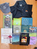 Group shot of all items including books, shirt, cap, accessory and bin