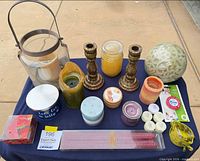Overview of entire lot on table showing candlesticks, lantern, assorted candles and adhesive