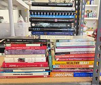Overall view of three stacks of assorted books on workbench