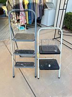 Front view of both folding step stools and wire basket