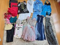 All items laid out including gowns, dresses, costumes, caps, accessories