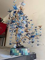 Full view of origami crane tree showing branch, birds and tiled base