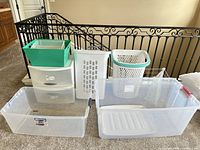 Overall view showing hampers, Sterilite drawer unit, green bin atop, large clear totes in front