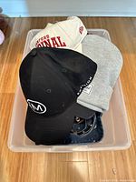 Bin containing multiple hats and earmuffs overview