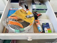 Drawer overview showing all packaged items including switches, weatherseal, screws, wall plates, GFCI and gloves
