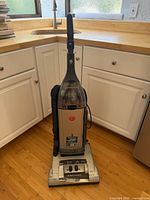 Front view of Hoover WindTunnel upright vacuum with hose and attachments visible