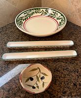 Group shot showing large pasta bowl, two long trays, small round olive bowl