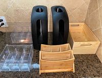 Group shot showing two black stainless steel bag dispensers, clear acrylic organizer, pine crate, bamboo organizer
