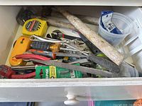 Drawer overview with tapes, stud sensor, pliers, screwdrivers, files, adjustable wrenches