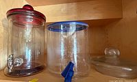 Glass and plastic dispensers side by side with spare lid visible