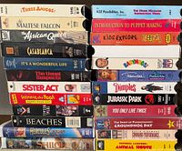 Overall view of two stacks of VHS tapes showing titles and conditions
