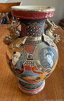 Front view showing figural panel, moriage detailing, Foo Dog handles