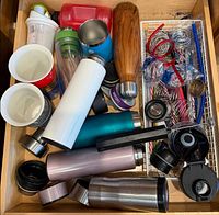 Drawer overview showing bottles, shaker, lids, balls and straws
