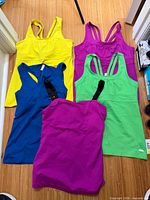 All five Gaiam tank tops laid out showing front colours