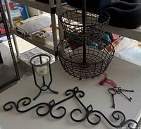 Group shot showing basket, candle holder, wall art piece, and keys on table