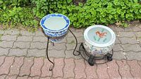 Both ceramic pots on their respective metal stands outdoors