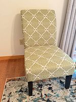 Front view of green patterned armless chair