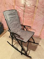 Full view of grey fabric folding rocking chair on black frame