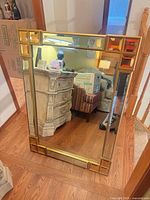Front view of rectangular mirror with gold frame and geometric accents