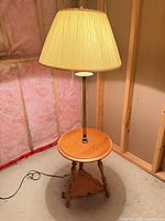 Full view of lamp table showing shade, metal column, wood table, legs, cord