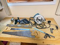 Group shot of circular saw, planer, hand saw, level, ruler, square, die grinder, spare blade
