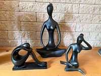 Three black female figure sculptures displayed together