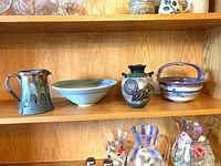 Group shot showing all four signed pottery pieces on shelf