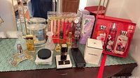 All vanity items arranged on dresser including brushes, perfumes, Chanel items, gift set