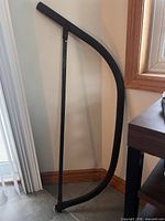 Full view of bow saw standing upright showing curved metal frame and blade