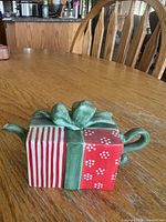 Front view of gift-box teapot showing bow lid, striped front and spout