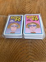 Two Women Over 50 decks side-by-side in plastic case, showing front graphics