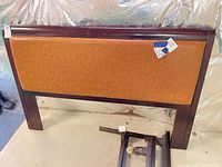 Front view of headboard showing wood frame and cognac panel