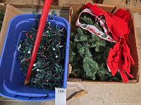 Blue tote containing tangled multicolour incandescent string lights and red pole visible