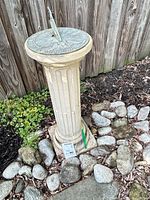Full view of fluted concrete pedestal sundial in garden setting
