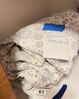 Folded snowflake-pattern flannel sheet set with note indicating full size and 100% cotton