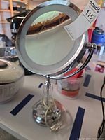 Front view of chrome LED makeup mirror on stand with MaxSold tag visible