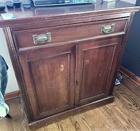 Front view of mahogany cabinet showing drawer and doors