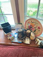 Overall view of mixed items on windowsill including tray, lampshade, boxes and decor pieces