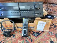 Front view of receiver on box with remote, antenna and dock visible