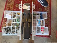 Toolbox closed with trays open showing mixed fasteners