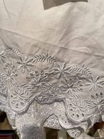 Close-up of eyelet embroidery on bed skirt showing floral pattern and scalloped edge