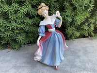Full view of Amy figurine front and side against foliage background