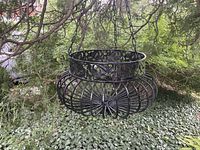 Full view of wrought iron planter hanging from tree