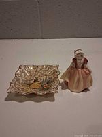 Royal Doulton figurine beside James Kent square dish
